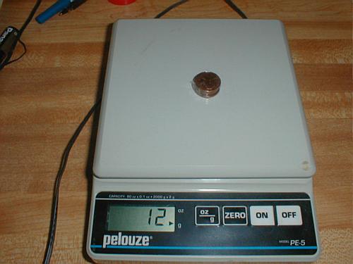 5 pennies on the scale weigh 12 g
